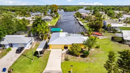 Street side aerial of 147 Coral Drive with the canal and river behind